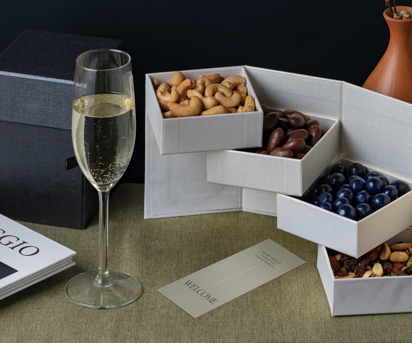 A beautifully lit boutique hotel room with a welcome amenities and glass of champagne.