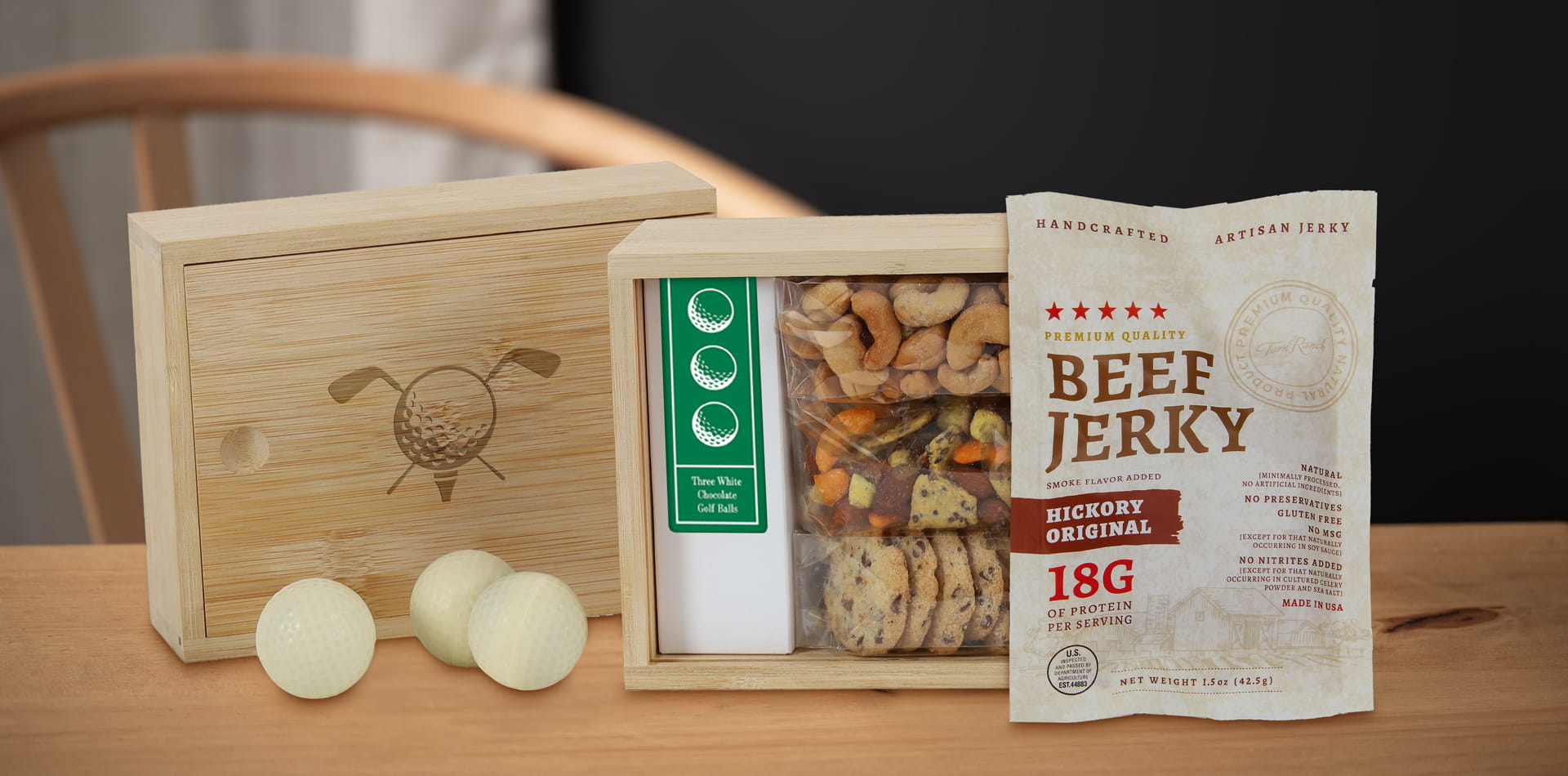 Torn Ranch Everwood 18 bamboo box open with golf balls and gourmet snacks.